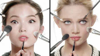 Two models with make up brushes surrounding their faces in Chanel the Beauty Guide commercial