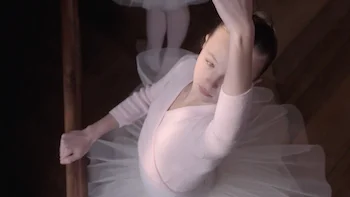 Jaeger Lecourtre commercial still of a young ballet dancer practicing a pose directed by Fabienne Berthaud
