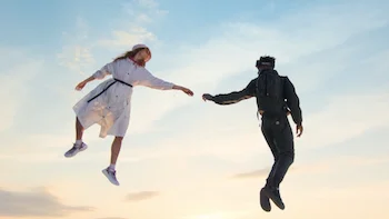 Summer of Lighthness 2022 film still of a couple in Moncler clothing reaching out to each othe while floating in the air
